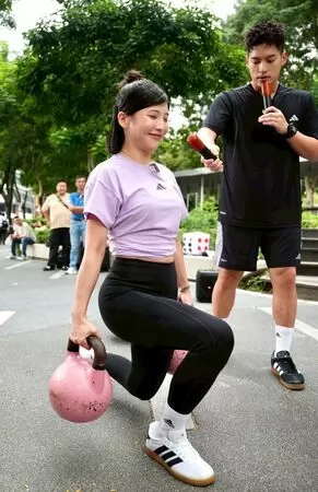 ▲許孟哲下場與民眾PK挑戰、壯壯示範壺鈴弓步走動作要領。（圖／TPF提供）