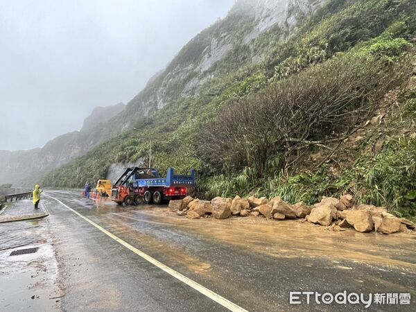 ▲國聖公墓旁的山壁土石崩落，多塊巨石滾落車道影響交通。（圖／記者郭世賢翻攝）