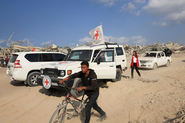 ▲▼紅十字會人員在哈瑪斯（Hamas）武裝分子的護送下，準備前往以色列軍隊根據停火協議撤到的加薩市「黃線」（yellow line）區域。（圖／路透）