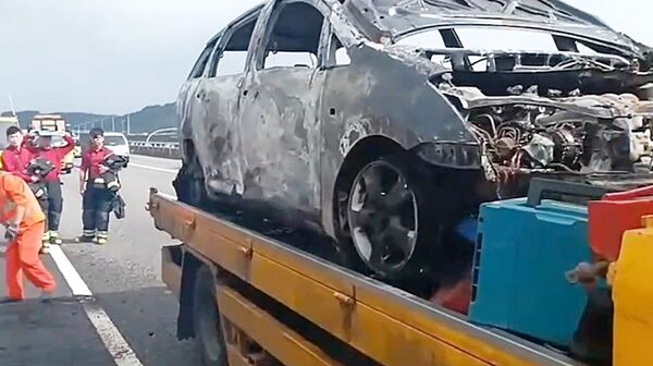 ▲國一五楊高架南向47公里處中午發生火燒車事故，警消撲滅火勢後，由拖吊車將燒成廢鐵休旅車脫離現場。（圖／桃市消防局提供）