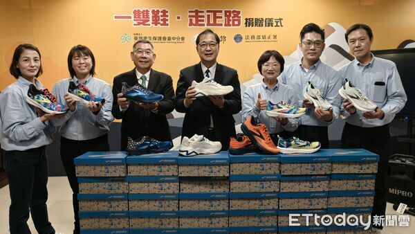 ▲▼台灣更生保護會台中分會主任廖學從（短髮戴眼鏡綠領帶）募集名牌全新運動鞋4000雙，捐贈矯正署將轉送近期出獄的弱勢受刑人，期許穿新鞋、走正路。（圖／記者黃哲民攝）