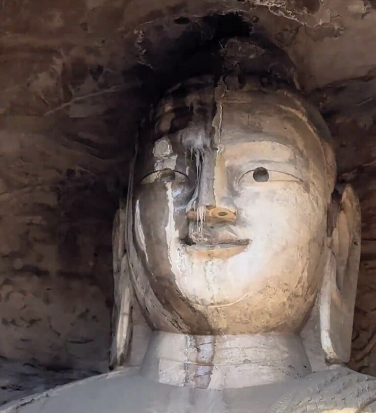 ▲雲岡石窟佛像面部滲水，在零下氣溫結成冰凌，宛如凍到「流鼻涕」。（圖／翻攝極目新聞）