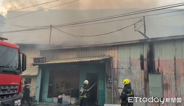 ▲台南市安南區安昌街鐵皮倉庫下午突發火警，消防人員迅速布水線搶救。（記者林東良翻攝，下同）