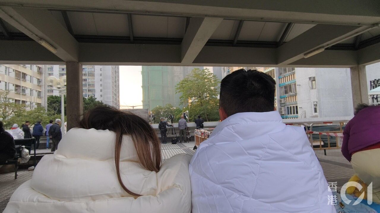 ▲不少住戶選擇待在可以看到宏福苑的露天收容平台，遙望家園。（圖／香港01）