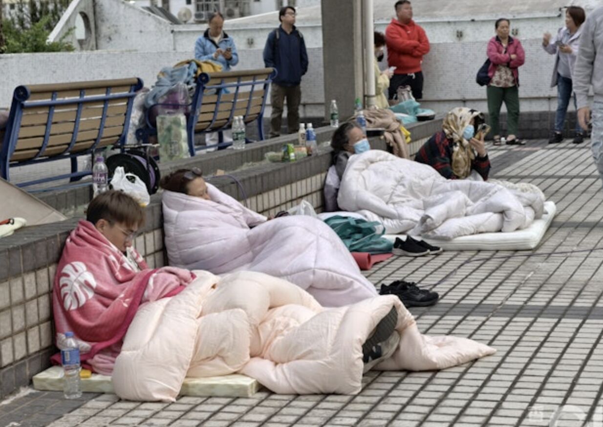 ▲不少住戶選擇待在可以看到宏福苑的露天收容平台，遙望家園。（圖／香港01）