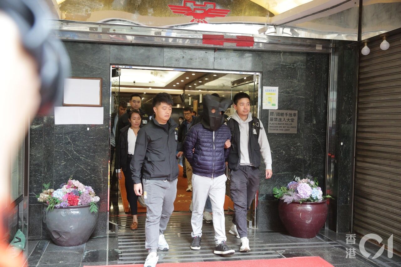 ▲港警從宏業建築工程有限公司帶走一名蒙頭的相關人士。（圖／香港01）