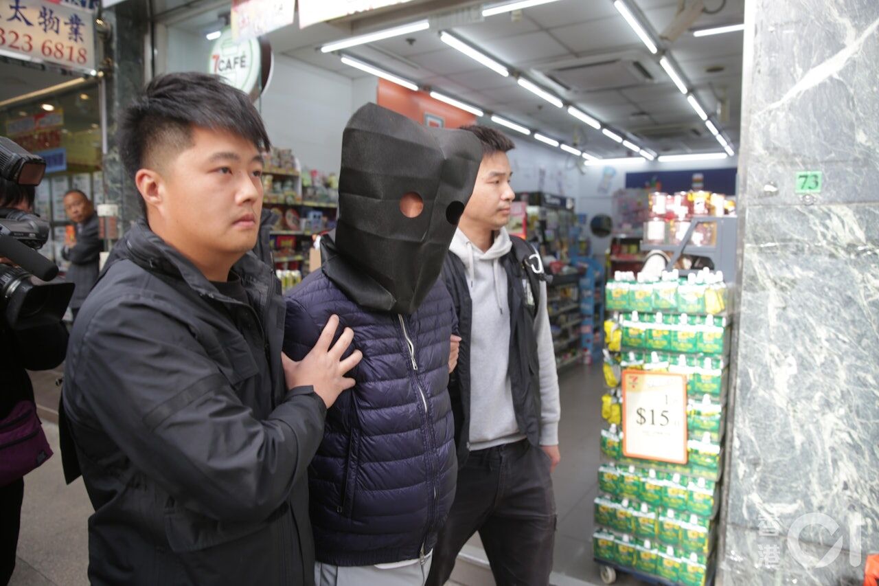 ▲港警從宏業建築工程有限公司帶走一名蒙頭的相關人士。（圖／香港01）