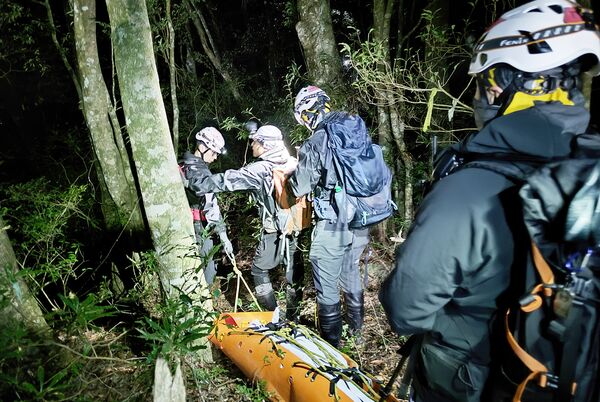 ▲桃園市七旬呂姓獵人26日前往復興區小烏來待矢負山巡視獵場，翌日仍未歸，家屬報案協尋，桃園消防局發動特搜義消共31人上山搜尋，昨天下午尋獲，但身體多數外傷已罹難，遂以人力辦運下山。（圖／桃園消防局提供）