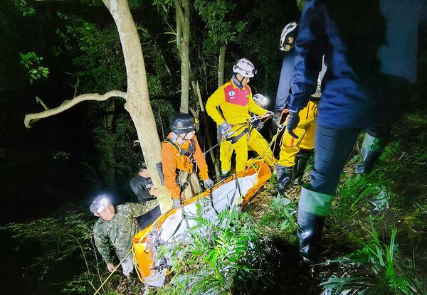 ▲桃園市消防局特搜義消共31人上山搜尋，以人力辦運罹難獵人遺體下山。（圖／桃園消防局提供）