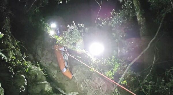 ▲桃園市消防局特搜義消以人力搬運罹難獵人遺體，克服陡峭山壁下山。（圖／桃園消防局提供）
