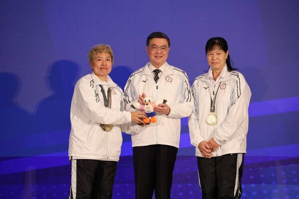 ▲2025年東京第25屆達福林匹克運動會返國餐會，由保齡球女子團體賽金牌選手張堯茜(左)、王玉琴(右)致贈大會吉祥物予行政院卓榮泰院長(中)。（圖／運動部提供）