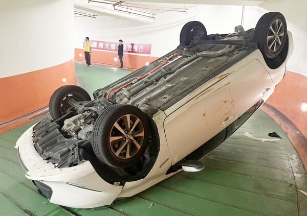 ▲許姓女子昨天下午駕駛租賃車進入桃園復興區某地下停車場時，失控擦撞撞牆壁後翻覆在坡道上。（圖／桃園警方提供）
