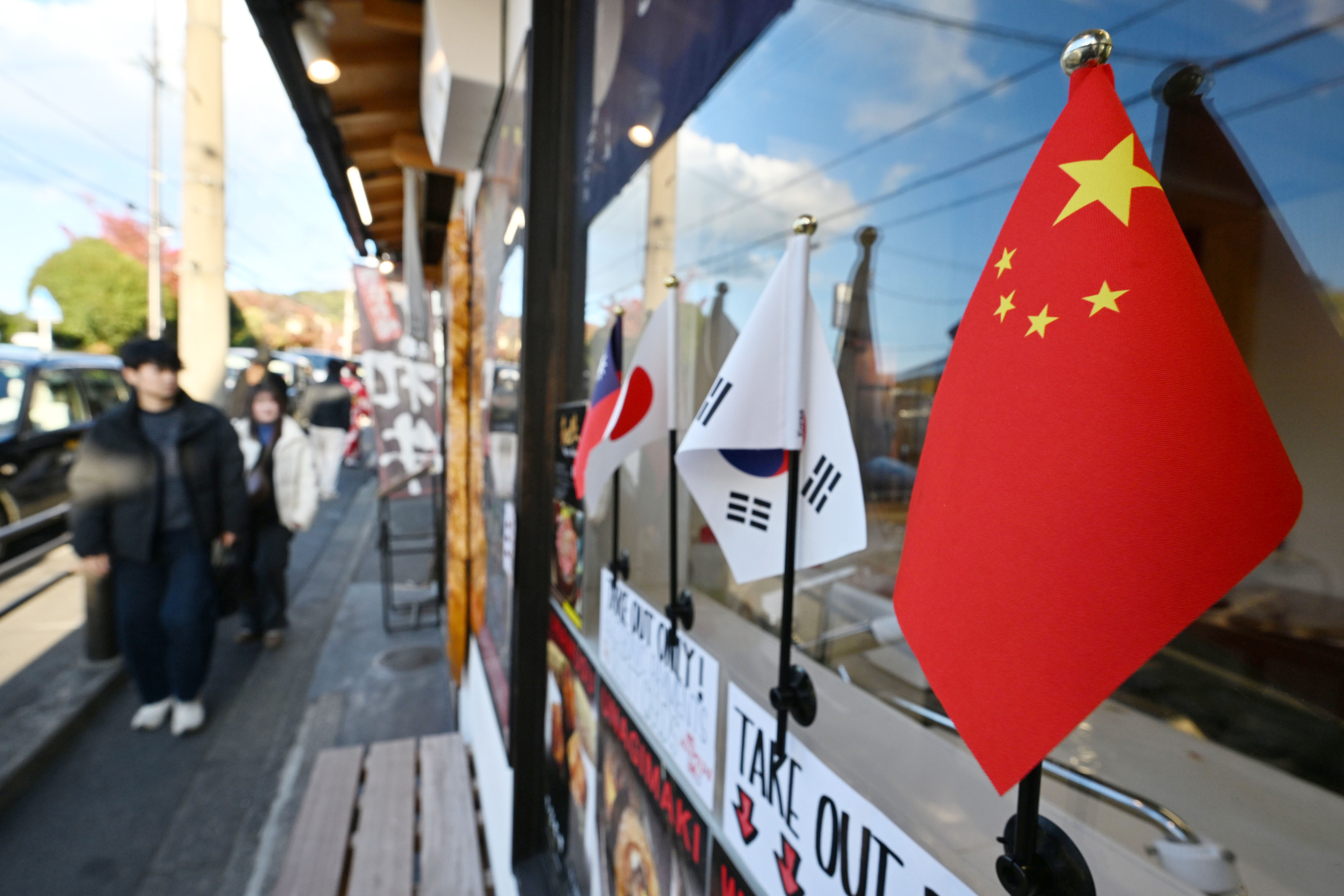 ▲▼在日本京都府京都市東山區，一名店員手持中文告示牌，在通往清水寺的路上指揮交通。（圖／達志影像／美聯社）