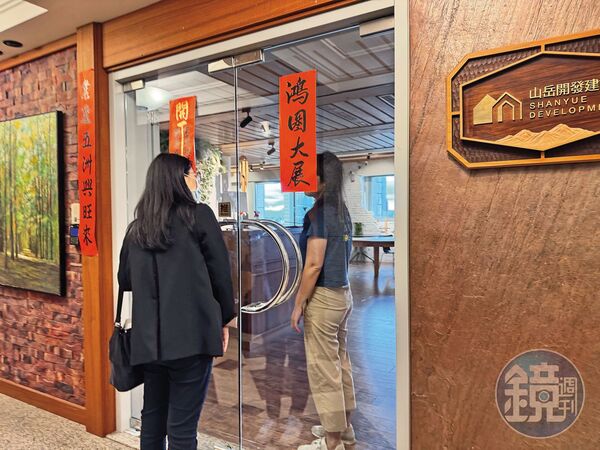 本刊前往山岳建設查證汐止都更爭議，一名女性員工（右）透過上鎖的玻璃門縫隙表示不回應。