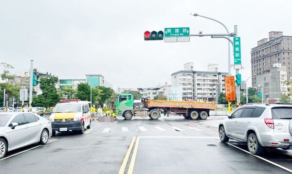 ▲桃園市龜山區興達路上，昨天一輛砂石車倒車載貨時，不慎輾過路口交通疏導林姓義交，警消到場急救。（圖／龜山警方提供）