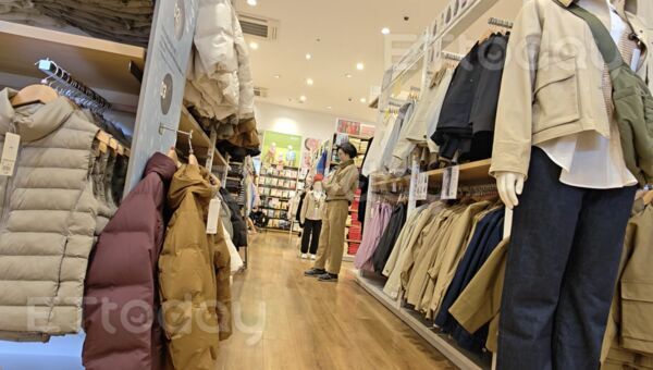 ▲林岱樺到日系平價連鎖服飾店購買外套，當場試穿             。（圖／記者吳奕靖攝）