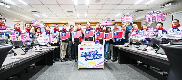 ▲桃園市長張善政帶領市府一級主管身為國旗圍巾，邀請市民芃穎參加明年在龜山區舉辦的元旦升旗典禮。（圖／市府新聞處提供）