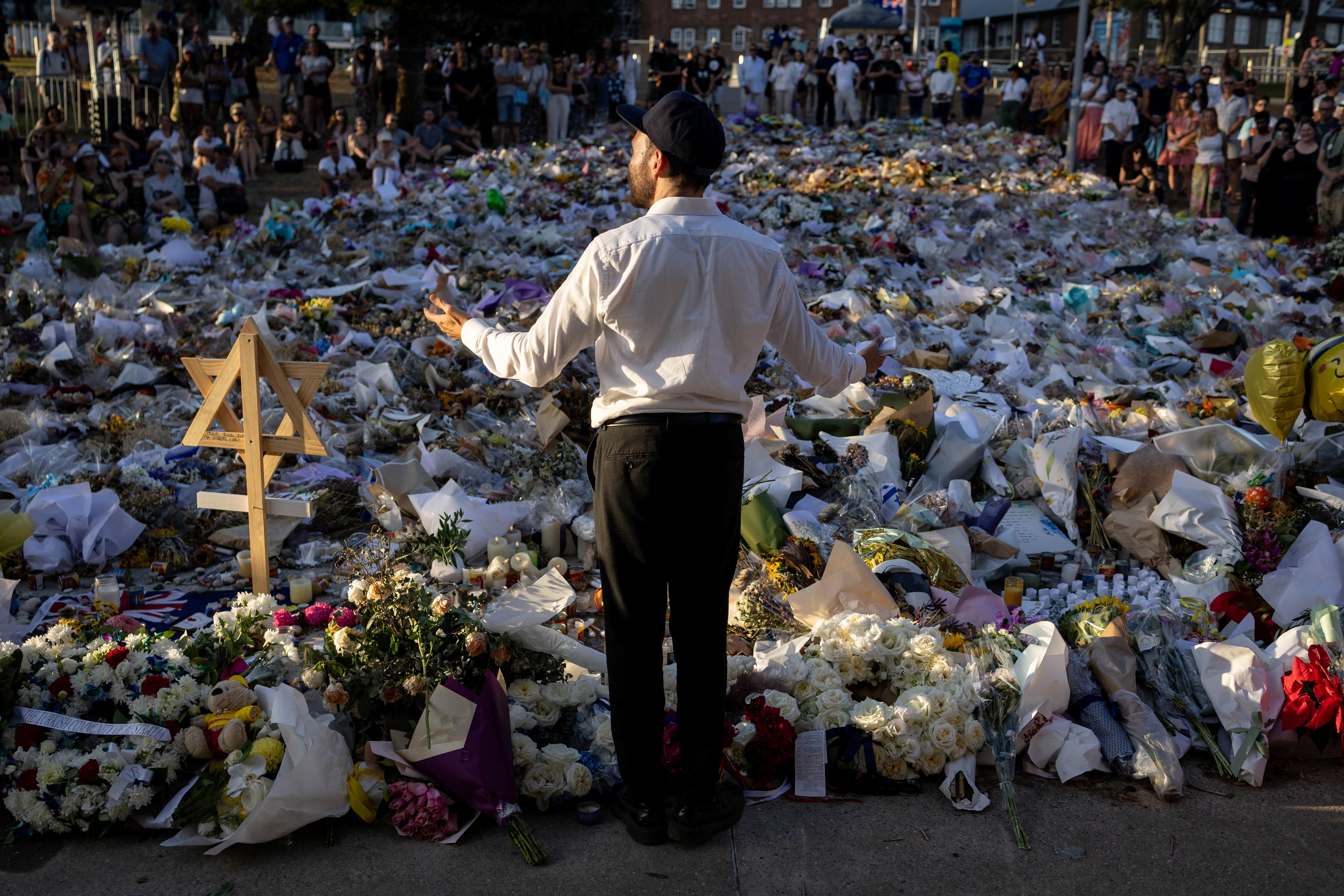 ▲▼在邦代海灘舉行的猶太光明節慶祝活動中，人們悼念大規模槍擊案的受害者。（圖／路透）