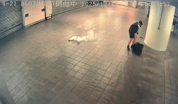 張文戴上防毒面罩，從行李箱中拿出煙霧彈，往捷運連通道丟擲。 （翻攝畫面）
