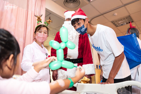 ▲海神3位球員聖誕節探訪高醫兒科病房、蘇文儒折氣球給兒科門診的孩童。（圖／高雄全家海神提供）