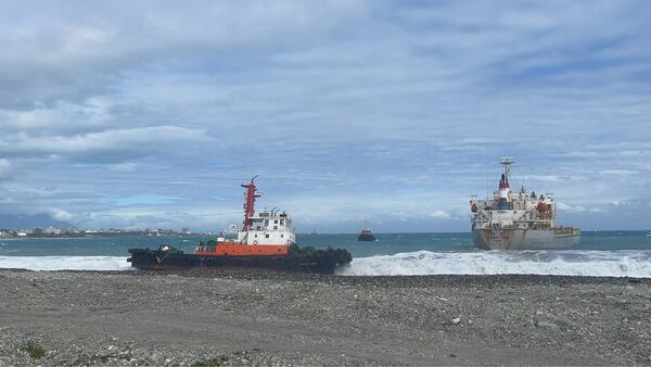 ▲中鋼運通「通鴻輪」(右)與拖船(左)雙雙擱淺在花蓮港。（圖／航港局提供）