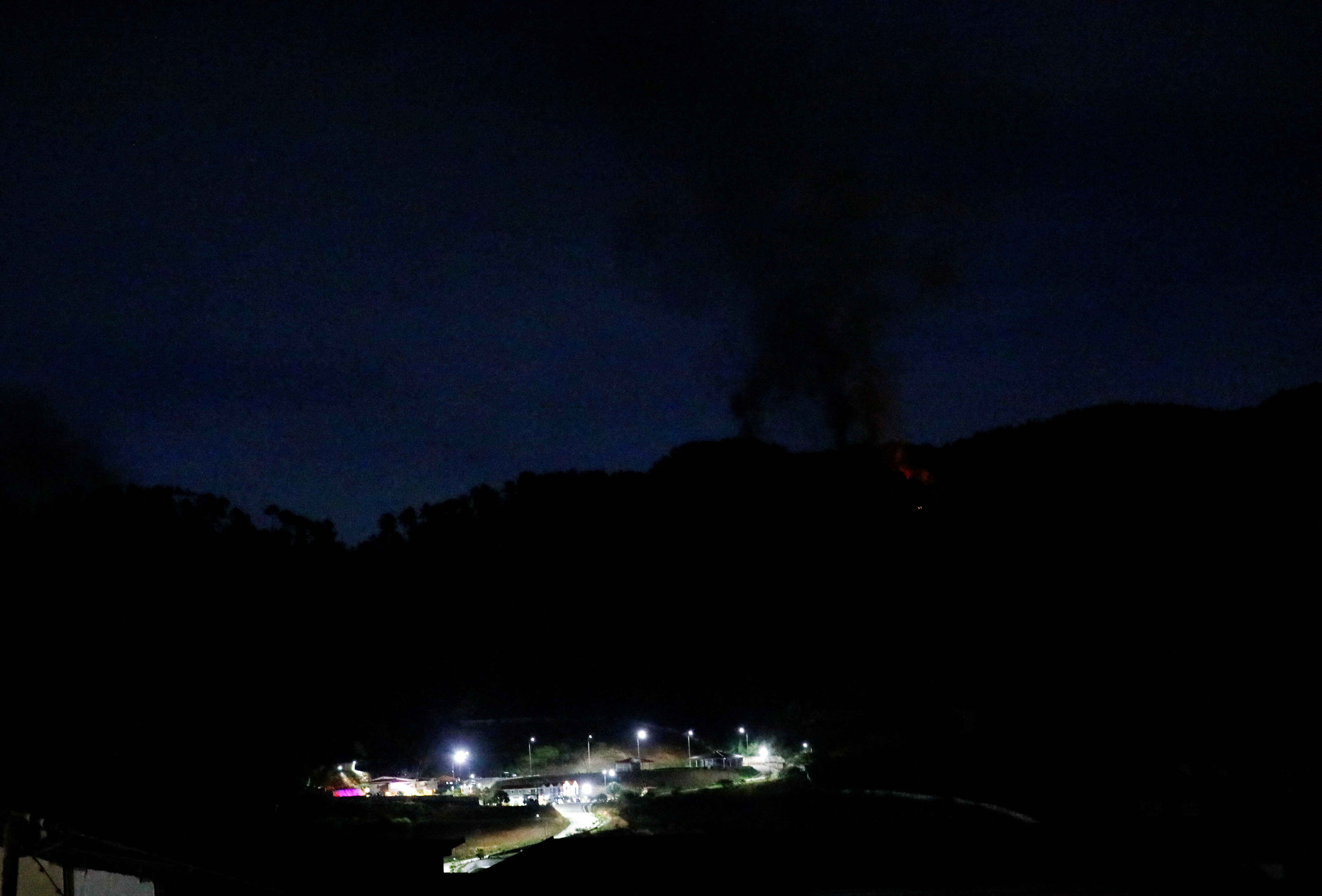 ▲▼ 委內瑞拉首都卡拉卡斯發生多起爆炸，重要軍事設施蒂烏納堡（Fort Tiuna）發生停電，一片漆黑中竄起濃煙。（圖／路透）