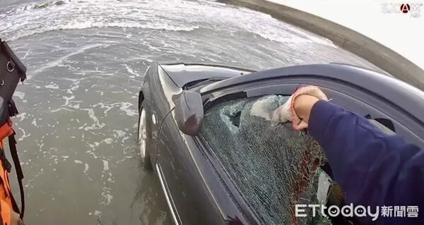 ▲轎車停放漁港水泥地快遭漲潮海水淹沒，警方破窗用大型農機救車。（圖／記者楊永盛翻攝）
