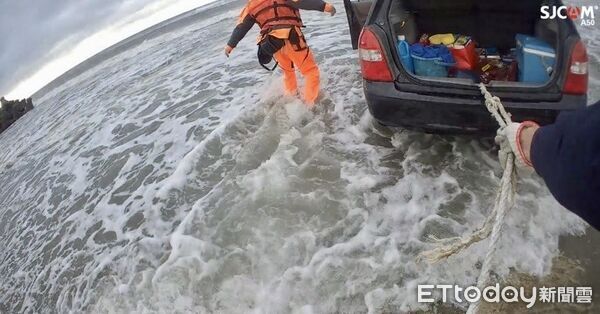 ▲轎車停放漁港水泥地快遭漲潮海水淹沒，警方破窗用大型農機救車。（圖／記者楊永盛翻攝）