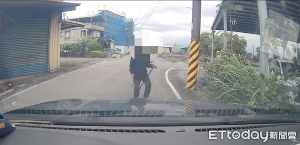 ▲▼蔡男右手拿斧頭、左手持拐杖的對著來往人車揮舞。（圖／記者游芳男翻攝，下同）