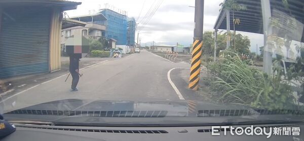 ▲▼蔡男右手拿斧頭、左手持拐杖的對著來往人車揮舞。（圖／記者游芳男翻攝，下同）