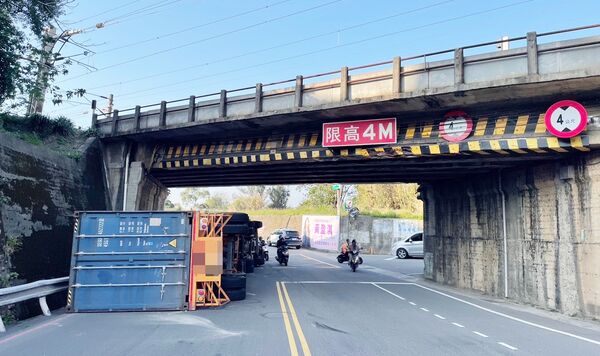▲一輛貨櫃車今天下午3時許行經桃園市楊梅區楊新路一段涵洞時，不慎撞擊涵洞入口上方導致翻覆，也造成該路段嚴重塞車。（圖／楊梅警方提供）