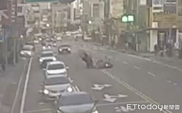 ▲美食外送員逕自路邊起步，切西瓜式跨越雙黃線迴轉，遭直行機車碰撞，機車與騎士翻飛落地。（圖／記者楊熾興翻攝、下同）