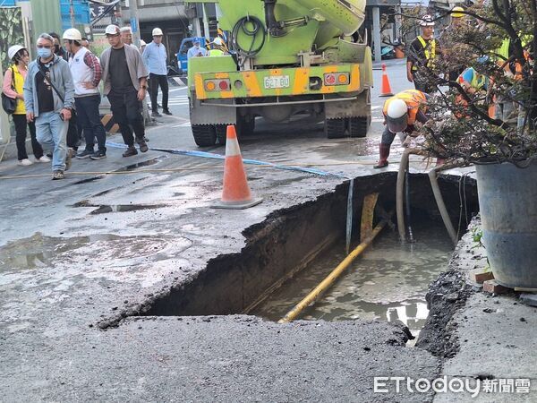 ▲台南市中西區五妃街近西門路口路面突下陷，出現長約2公尺、深近2公尺的大型坑洞，坑洞下方自來水管線裸露漏水，工務局緊急通知自來水公司到場搶修，並灌漿回填。（圖／記者林東良翻攝，下同）