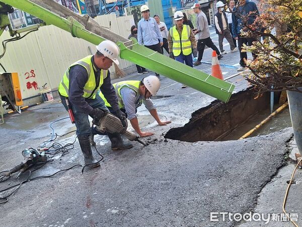▲台南市中西區五妃街近西門路口路面突下陷，出現長約2公尺、深近2公尺的大型坑洞，坑洞下方自來水管線裸露漏水，工務局緊急通知自來水公司到場搶修，並灌漿回填。（圖／記者林東良翻攝，下同）
