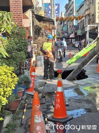 ▲台南市中西區五妃街近西門路口路面突下陷，出現長約2公尺、深近2公尺的大型坑洞，坑洞下方自來水管線裸露漏水，工務局緊急通知自來水公司到場搶修，並灌漿回填。（圖／記者林東良翻攝，下同）