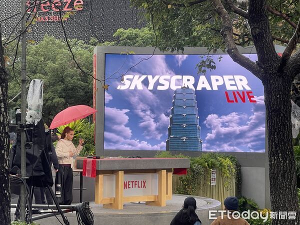 ▲▼ 美國自由攀岩名將霍諾德（Alex Honnold）於台灣時間24日挑戰徒手攀登台北101,主辦方Netflix於台北101對面「信義廣場」架設大型轉播螢幕，進行實況轉播。（圖／記者李毓康攝）