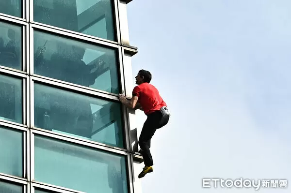 ▲▼美國自由攀岩名將霍諾德（Alex Honnold）於台灣時間25日挑戰徒手攀登台北101，101大樓內也有民眾拿手機隔著玻璃拍攝。（圖／記者李毓康攝）