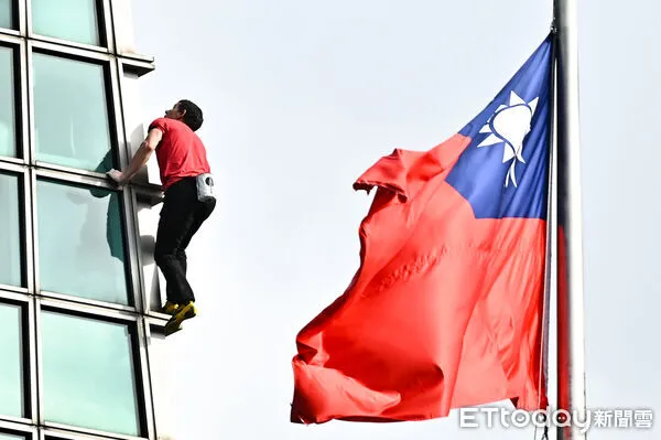 ▲▼美國自由攀岩名將霍諾德（Alex Honnold）於台灣時間25日挑戰徒手攀登台北101，攀爬時剛好與101大樓前懸掛的國旗相互映襯。（圖／記者李毓康攝）