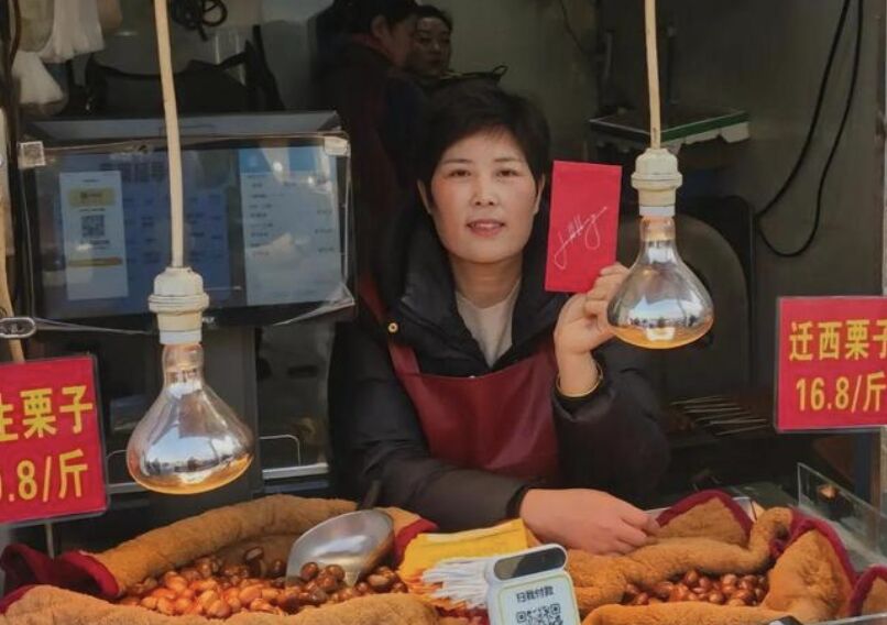 ▲上海菜市場攤商拿到黃仁勳600元人民幣簽名紅包。（圖／翻攝極目新聞）