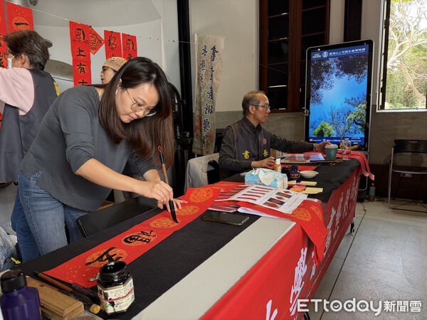 ▲台南水道博物館舉辦馬年揮毫送祝福活動，長榮大學師生現場揮毫，吸引遊客熱情索取春聯。（記者林東良翻攝，下同）