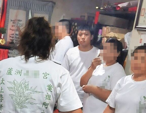 廖聰賢（箭頭處）曾與父親一同參加宮廟活動，留下唯一的正面照。（翻攝畫面）