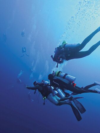 潘慧如（中）日前在馬爾地夫首度深潛到水下35公尺，突發呼吸困難的恐慌症狀，趕緊上前拉住潛導員。（球狀星團娛樂公司提供）