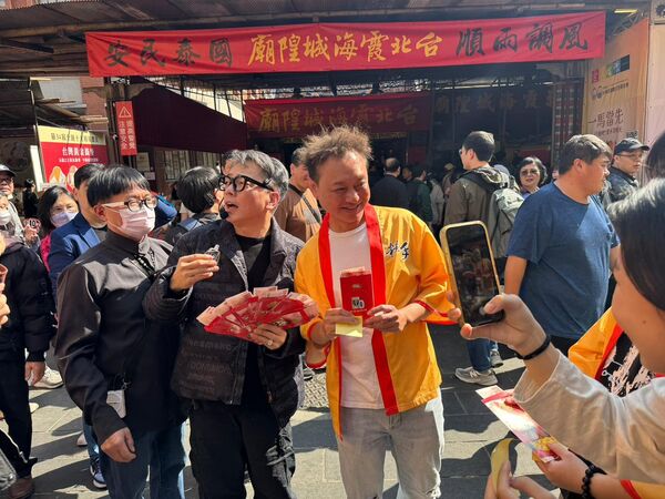 ▲▼詹惟中老師於霞海城隍廟前廣場發送開運紅包，民眾領到開心合影。（圖／陳孝志提供）