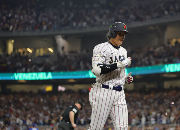 ▲日本在邁阿密舉行的世界棒球經典賽8強賽不敵委內瑞拉後，大谷翔平15日在維安人員陪同下走過球場通道。（圖／達志影像／美聯社）