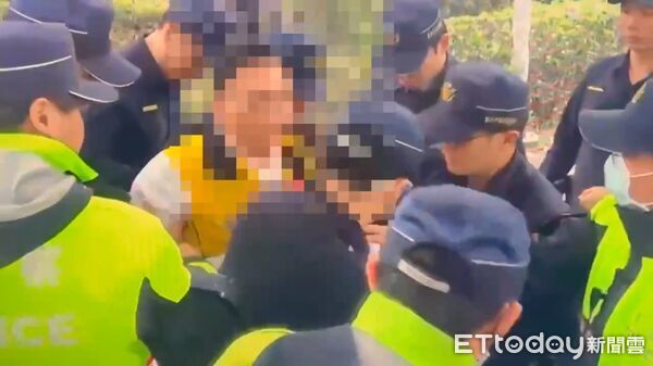 ▲北市議員候選人游智彬參加挺科大遊行丟水球遭多名警員管束。（圖／記者張君豪翻攝）