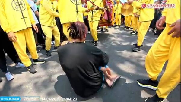 ▲媽媽跪地抱幼兒求媽祖賜福。（圖／翻攝自白沙屯媽祖網路電視台）