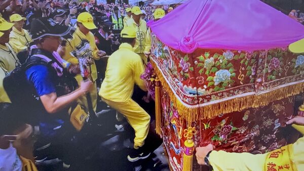 ▲媽媽跪地抱幼兒求媽祖賜福。（圖／翻攝自白沙屯媽祖網路電視台）