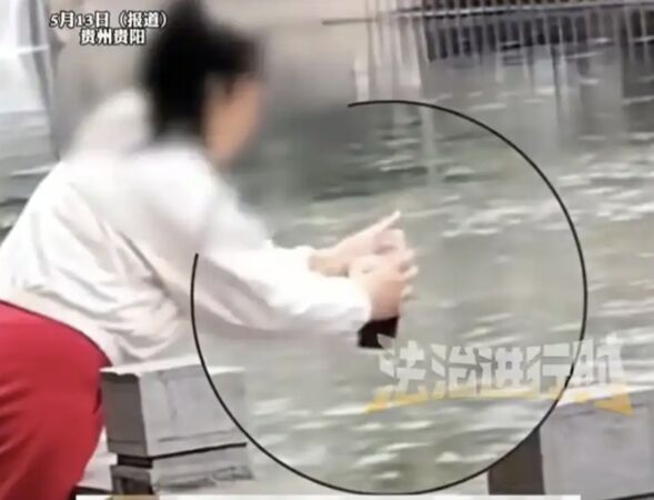 ▲▼陸女「放生奶茶」　邊唸經邊往河裡狂倒。（圖／翻攝微博）