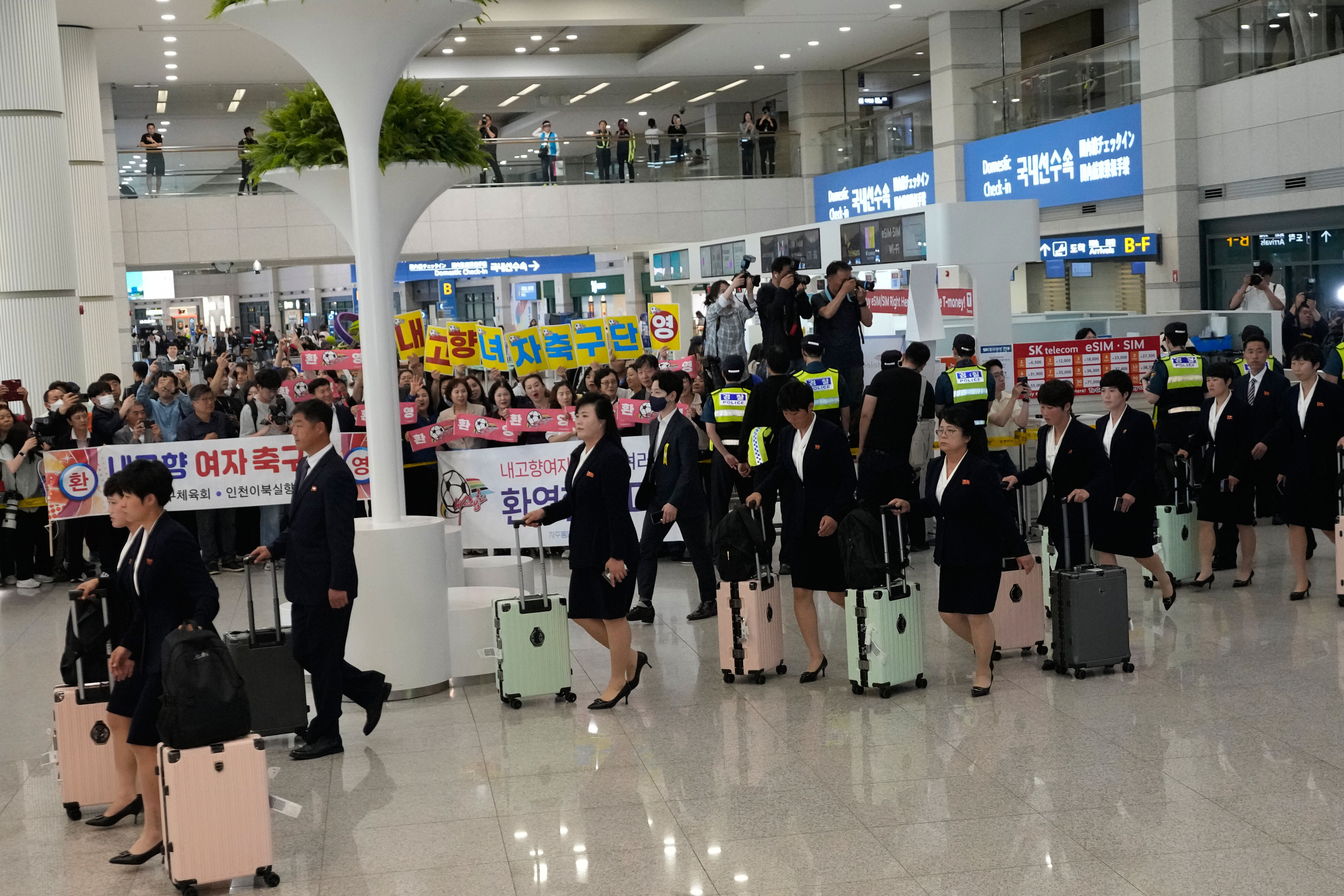 ▲▼北韓女子足球隊「我故鄉」飛抵仁川機場，南韓脫北者與主張統一等相關團體舉牌迎接。（圖／達志影像／美聯社）