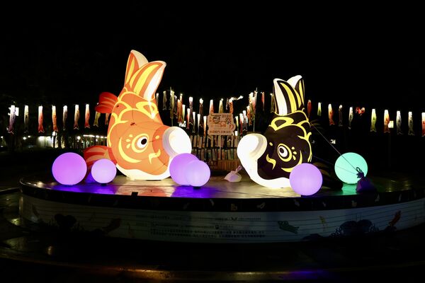 ▲「2026北投夏日祭り」即日起至6月21日登場，北投公園噴水池上方設有2隻鯉魚裝置，營造「鯉魚躍龍門」夜色。（圖／北市商業處提供）